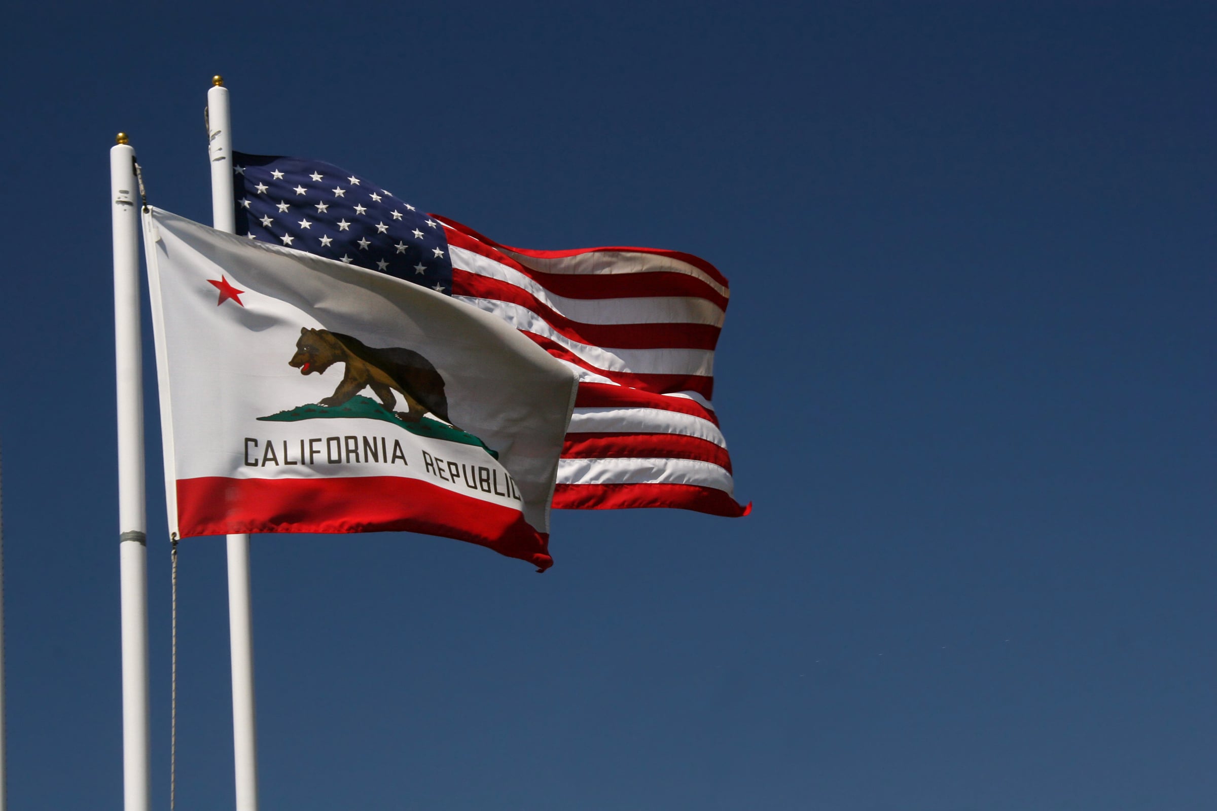 California and United States flags flying together on poles